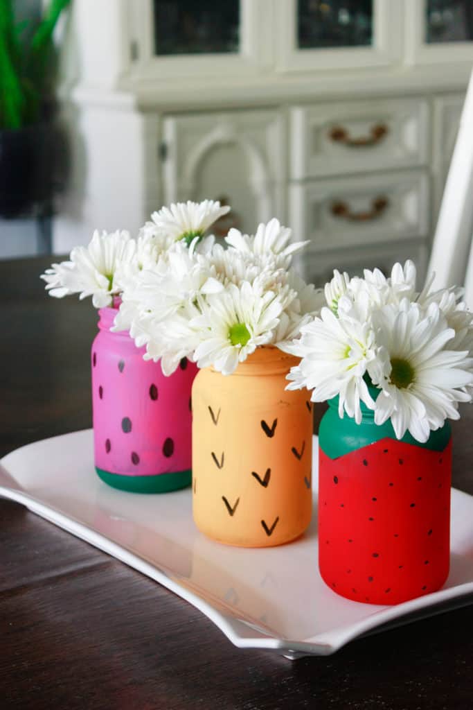 Three painted Mason jar decorations.