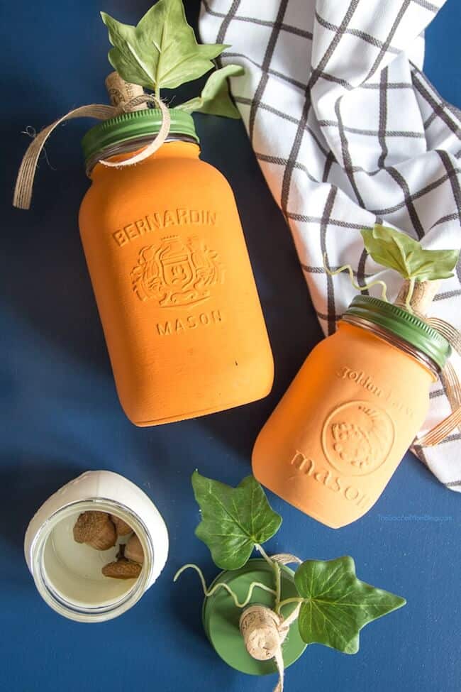 Two Mason Jar Crafts Painted To Look Like Pumpkins