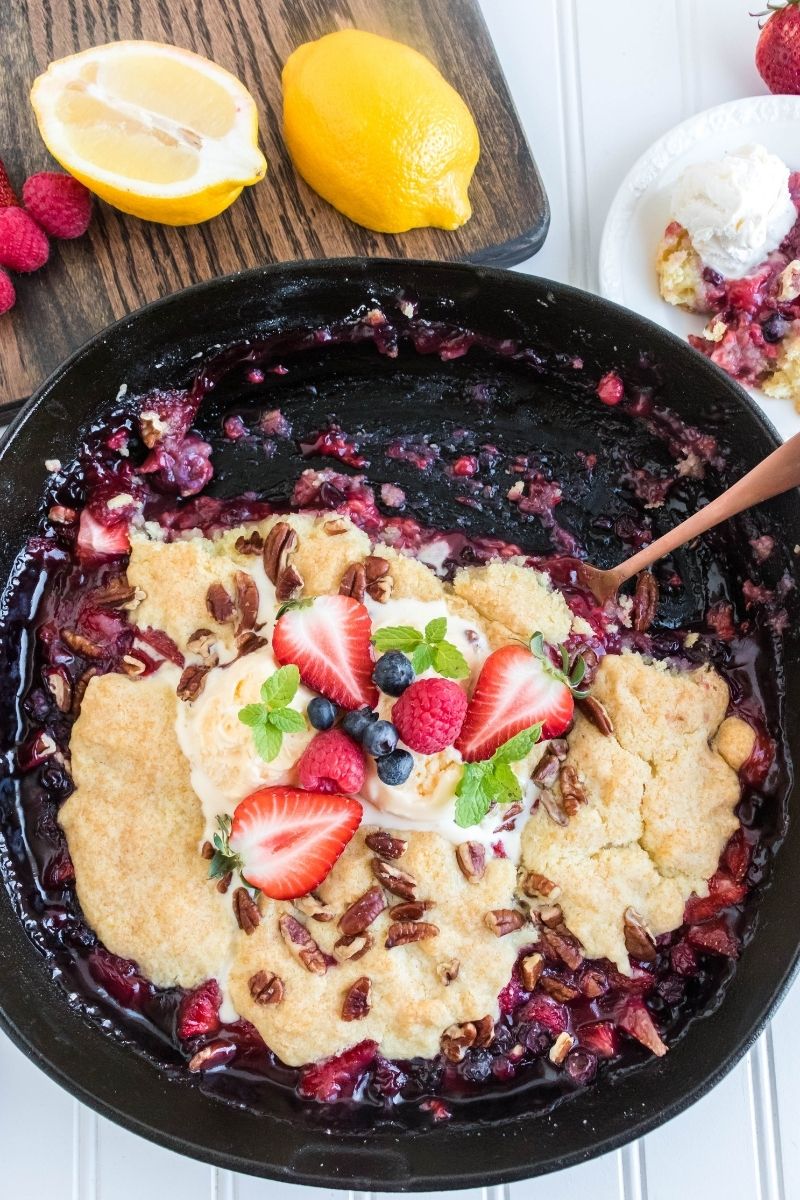fruit cobbler with spoon in a cast iron skillet