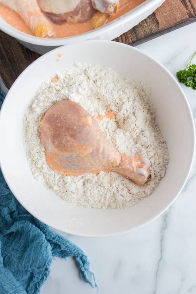 dipping chicken into flour mixture