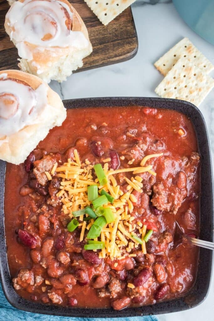 bowl with stovetop chili topped with cheese and green onions