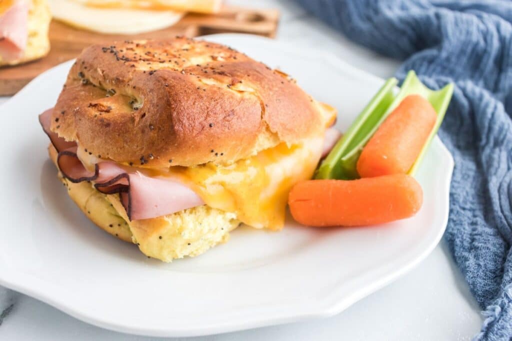 plate with ham and cheese sandwich and carrots and celery