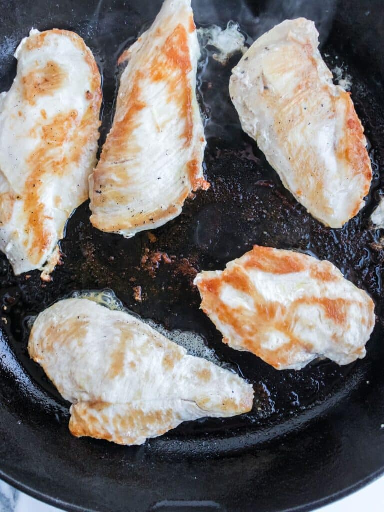 skillet with golden brown chicken breasts