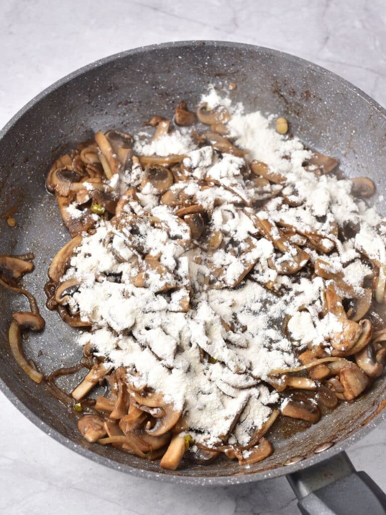 adding flour to mushrooms