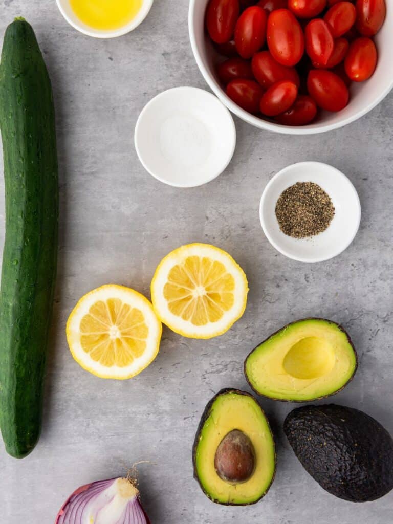 cucumber, tomatoes, lemons and avocados on countertop