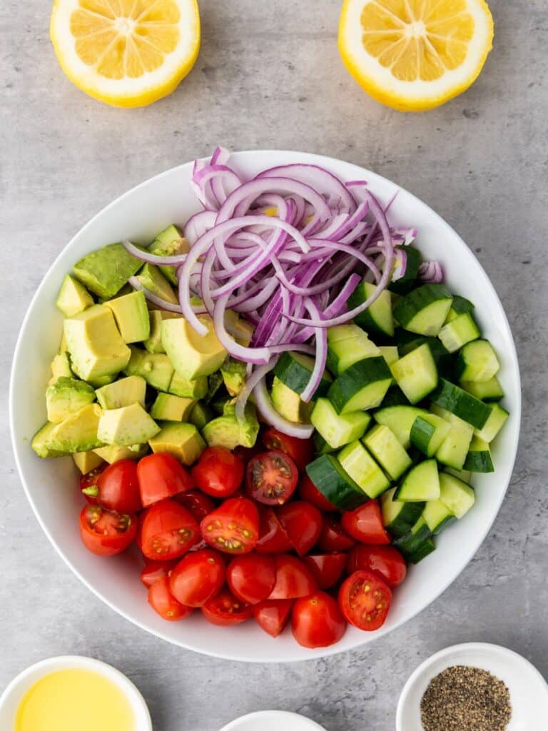 bowl with fresh tomatoes, avocados, cucumbers and red onions